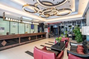 een lobby met rode stoelen en een grote kroonluchter bij Guangzhou Yunshang Airport Hotel Free shuttle airport bus in Guangzhou