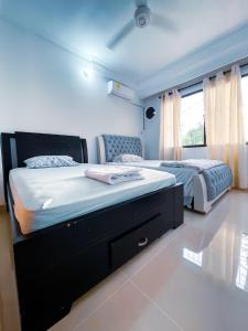 een slaapkamer met 2 bedden en een groot raam bij Casa a una cuadra del mar in Tolú