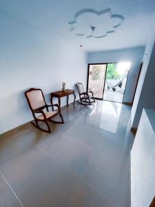 een woonkamer met 2 stoelen en een tafel bij Casa a una cuadra del mar in Tolú