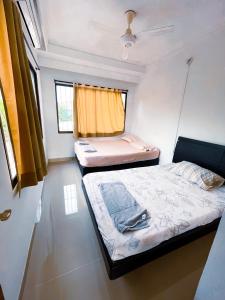 twee bedden in een kleine kamer met een raam bij Casa a una cuadra del mar in Tolú
