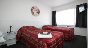 a hotel room with a bed and a chair at Brown Trout Motel in Pahiatua