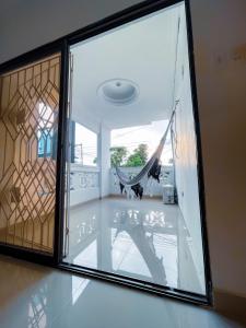 een glazen deur met een hangmat in een kamer bij Casa a una cuadra del mar in Tolú