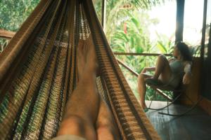馬爾多納多港的住宿－Tronco Tambopata Adventure，坐在吊床上坐在椅子上的女人