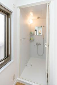 a white shower in a bathroom with a window at My Retreat Osaka in Osaka