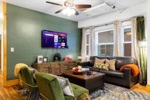 a living room with a couch and a tv at Modern Century Loft At The Pillars in Cleveland