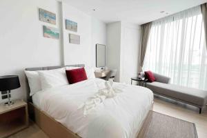 a white bedroom with a bed and a couch at Edge Central Pattaya BJ in Pattaya Central