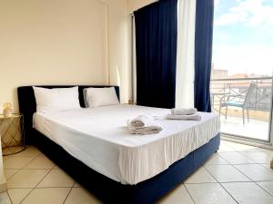 a bedroom with a bed with white sheets and a window at enJoy in Tripoli