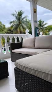 a balcony with two wicker couches and palm trees at Hotel Quinta Ana María in Melgar