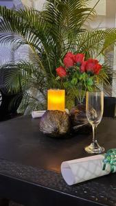 a table with a glass and a candle and flowers at Hotel Quinta Ana María in Melgar