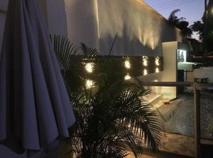 a patio with a umbrella and a plant and lights at Hotel Quinta Ana María in Melgar