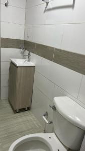 a bathroom with a toilet and a sink at Hotel Quinta Ana María in Melgar