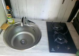 a kitchen sink with a stove and a sink at Green Palma in Kutaisi