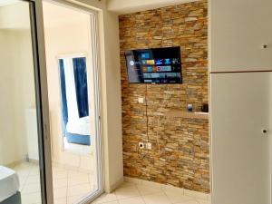 a shower in a bathroom with a stone wall at enJoy in Tripolis