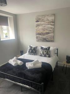 1 dormitorio con 1 cama con 2 toallas en Fern House - 2bedroom house Free Parking Town centre by Shortstays4u, en Kings Lynn