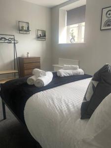 1 dormitorio con 1 cama grande y toallas. en Fern House - 2bedroom house Free Parking Town centre by Shortstays4u, en Kings Lynn