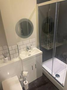 baño blanco con ducha y lavamanos en Fern House - 2bedroom house Free Parking Town centre by Shortstays4u, en Kings Lynn