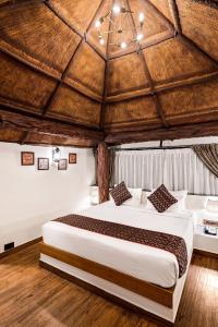 Vijayshree Resort, Hampi في هامبي: غرفة نوم بسرير كبير في غرفة