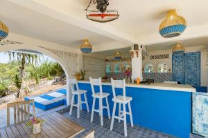 an outdoor kitchen with a blue counter and stools at Kov Ceningan in Nusa Lembongan