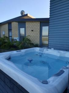 un bain à remous en face d'une maison dans l'établissement Vineyard Vacation, à Mangawhai