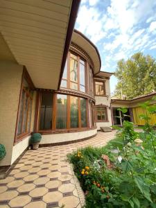 a house with a patio and a yard with flowers at Sultan Sarai Osh in Osh