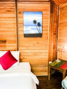 a bedroom with a bed with a red pillow and a window at Villa Russerangan Grand Opening in Praya