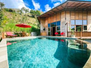 a swimming pool in front of a house at Villa Russerangan Grand Opening in Praya