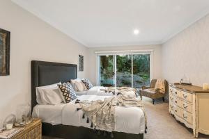 a bedroom with a bed and a couch and a window at Lakes Edge in Daylesford