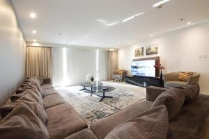 sala de estar con sofá grande y TV en SHH - D1 Tower Apartments, en Dubái
