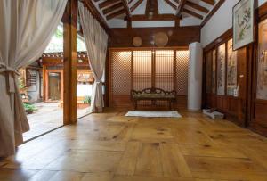 a living room with a wooden floor and a couch at Dongmyo Hanok Sihwadang - Private Korean Style House in the City Center with a Beautiful Garden in Seoul