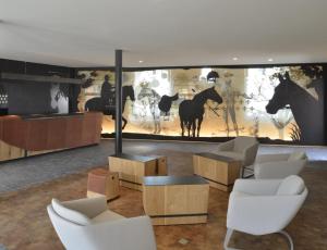 a living room filled with furniture and a horse statue at Hotel Les Haras in Strasbourg