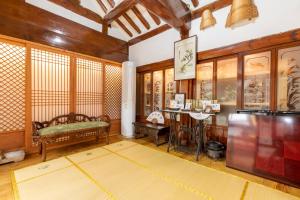 a living room with a couch and a table at Dongmyo Hanok Sihwadang - Private Korean Style House in the City Center with a Beautiful Garden in Seoul