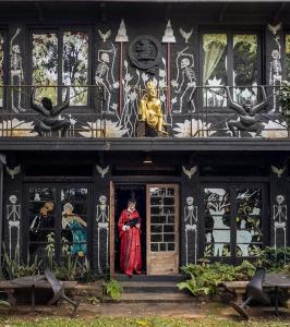a building with a woman standing in the doorway at HELGASFOLLY Anti Hotel Residence in Kandy