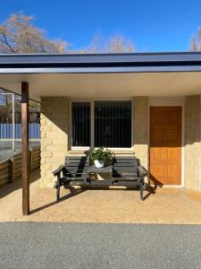a patio with two chairs and a table in front of a house at Riverside Studio in Wanaka