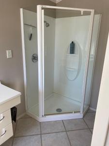 a shower with a glass door in a bathroom at Riverside Studio in Wanaka