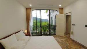 ein Schlafzimmer mit einem Bett und einem großen Fenster in der Unterkunft The Oxford Villa at Venus by Flamingo Dai Lai Resort in Phúc Yên