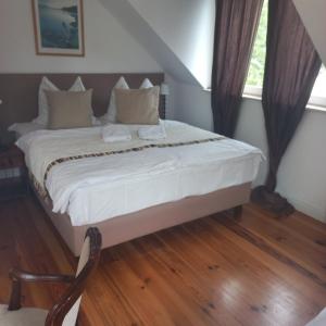 a bedroom with a bed with white sheets and pillows at Rewa in Rewal