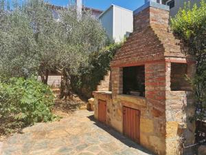 a brick building with a red door in a yard at Villa Elli in Alexandroupoli
