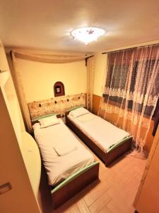 two beds in a small room with a window at Villa Elli in Alexandroupoli