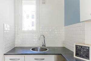 uma cozinha com um lavatório e uma janela em Bright apartment - 2BR - Place de la BastilleSt Antoine em Paris