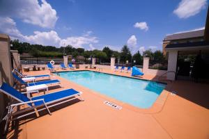 uma grande piscina com espreguiçadeiras azuis em Holiday Inn Express Hotel & Suites Atlanta East - Lithonia, an IHG Hotel em Lithonia