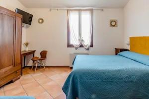 een slaapkamer met een bed, een bureau en een raam bij Locanda delle grotte di Onferno in Gemmano