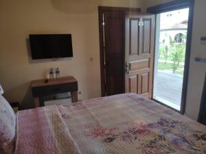 a bedroom with a bed and a tv and a window at Tarihi Kumbaba Otel in Şile