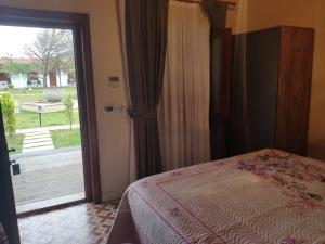a bedroom with a bed and a sliding glass door at Tarihi Kumbaba Otel in Sile