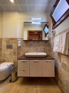 a bathroom with a sink and a toilet and a mirror at Tarihi Kumbaba Otel in Sile