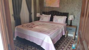 a bedroom with a bed with a purple comforter at Tarihi Kumbaba Otel in Sile