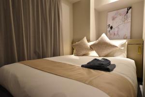 a hotel room with a bed with a robe on it at Hotel Cordia Osaka Hommachi in Osaka