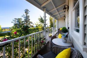 a porch with a table and chairs on a balcony at Little Wombat Daylesford in Daylesford