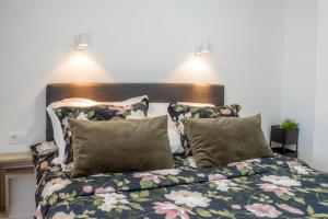 a bed with floral sheets and pillows in a bedroom at Apartment Ladan in Trogir