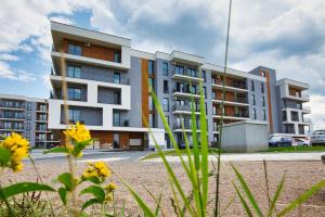 an apartment building with yellow flowers in front of it at Black Goat 81 Apartaments in Zator