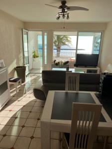 a living room with a couch and a table at Appartement Mar e Souleu avec Terrasse et Vue Mer au Grau du Roi in Le Grau-du-Roi